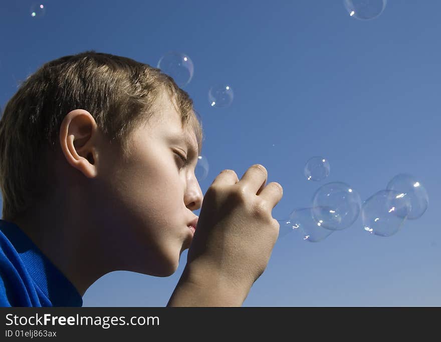 Boy blowing soap bubbles