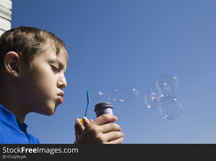 Boy blowing soap bubbles