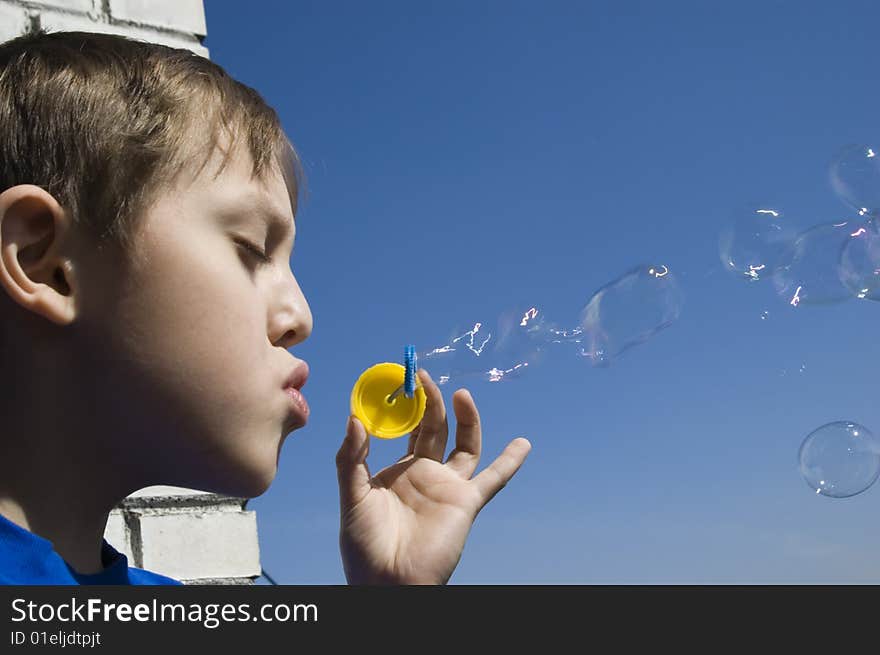 a boy blowing soap bubbles