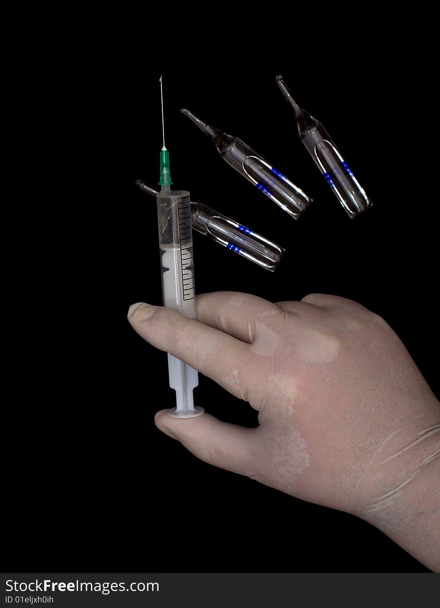 Syringe in a hand and ampoules