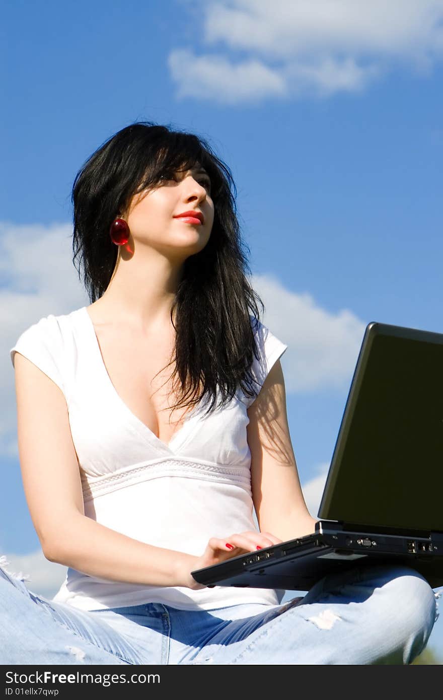 Pretty woman with laptop on sky background