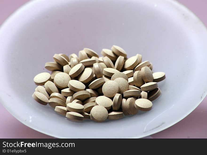 Mitamins in a bowl on a table. Mitamins in a bowl on a table