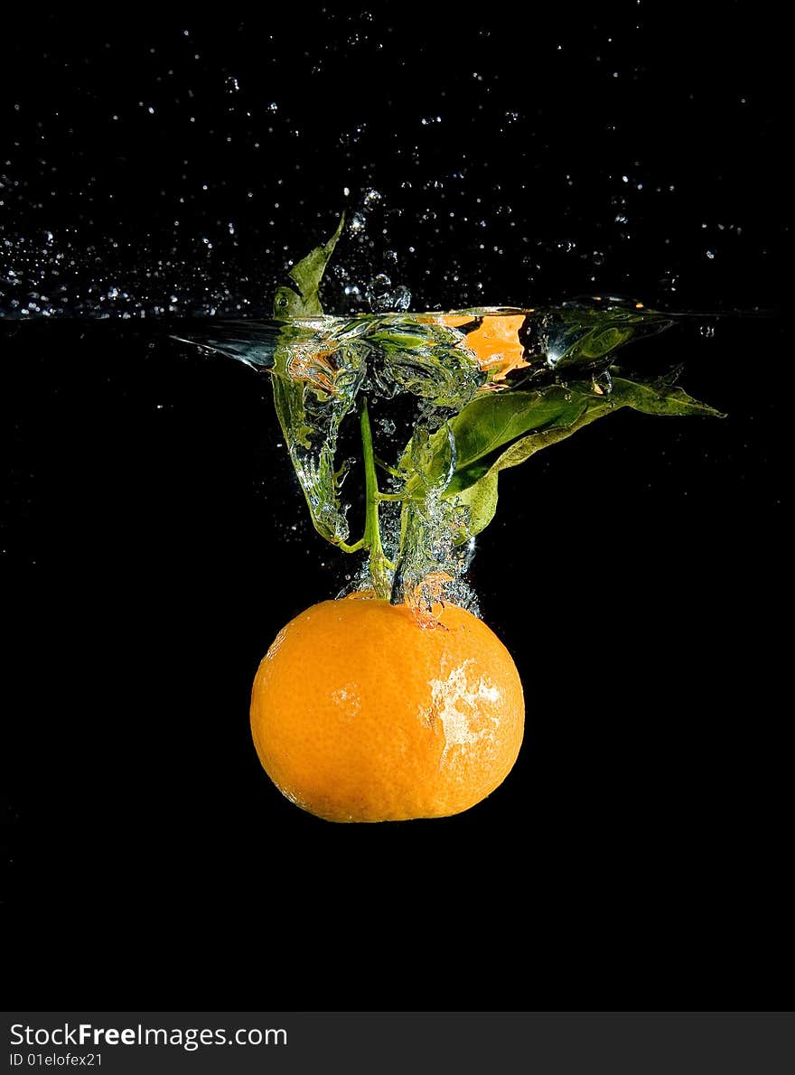 Tangerine in water with bubbles on black ground. Tangerine in water with bubbles on black ground