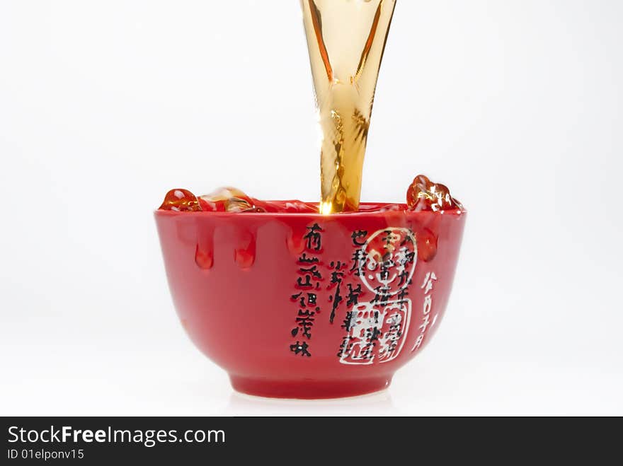 Pouring tea into chinese red teacup. Pouring tea into chinese red teacup