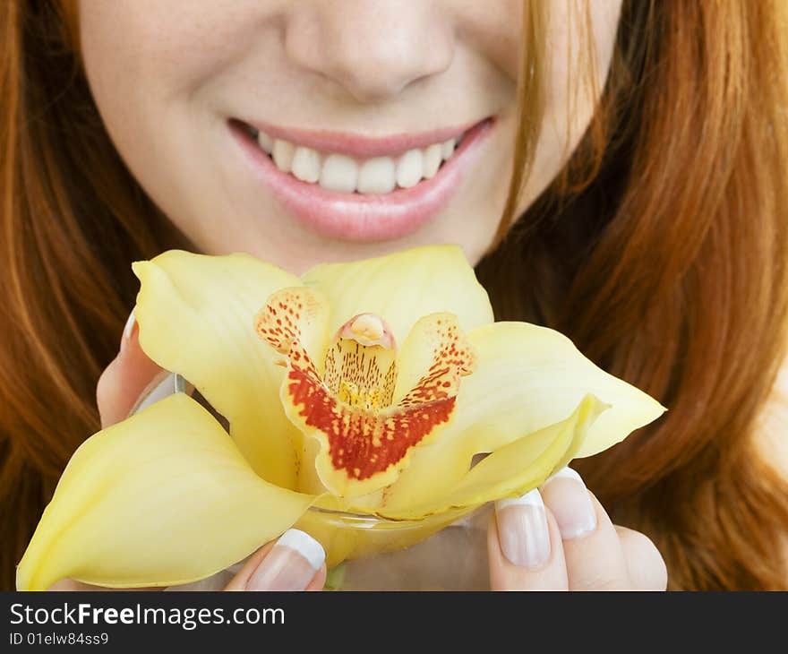 Close up of a orchid at girl's hands and her smile, focus on flower. Close up of a orchid at girl's hands and her smile, focus on flower