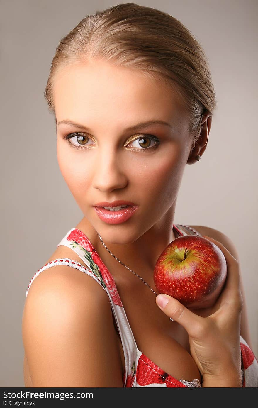 Attractive young woman holding red apple