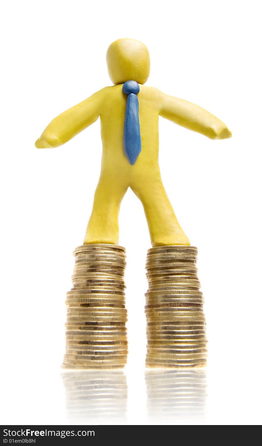 Plasticine businessman stands on two heaps of gold coins. Plasticine businessman stands on two heaps of gold coins