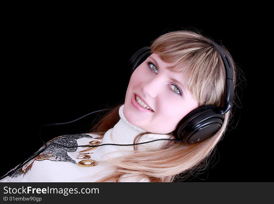 Young girl with headphones on black background