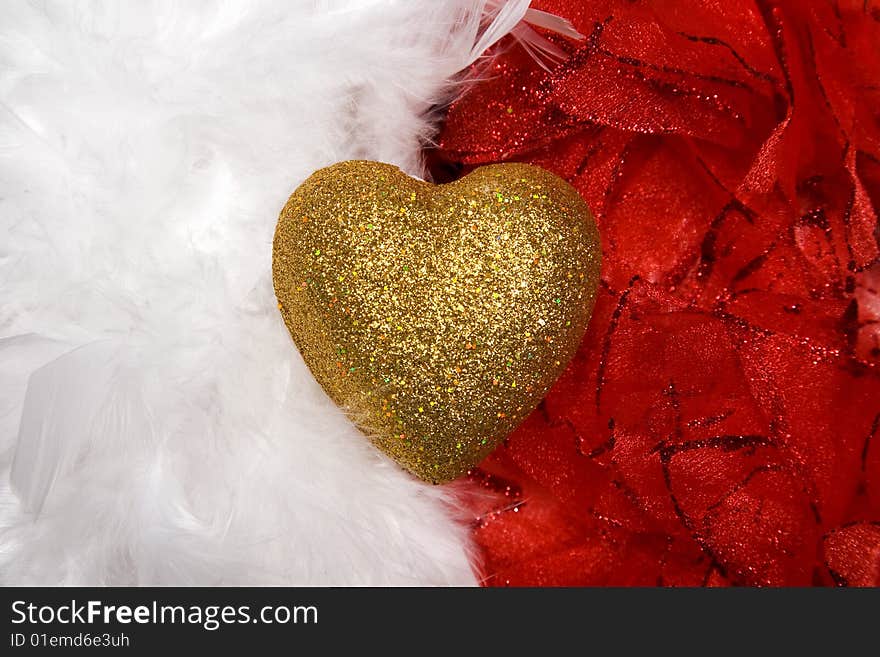 Golden heart over white and red feathers background