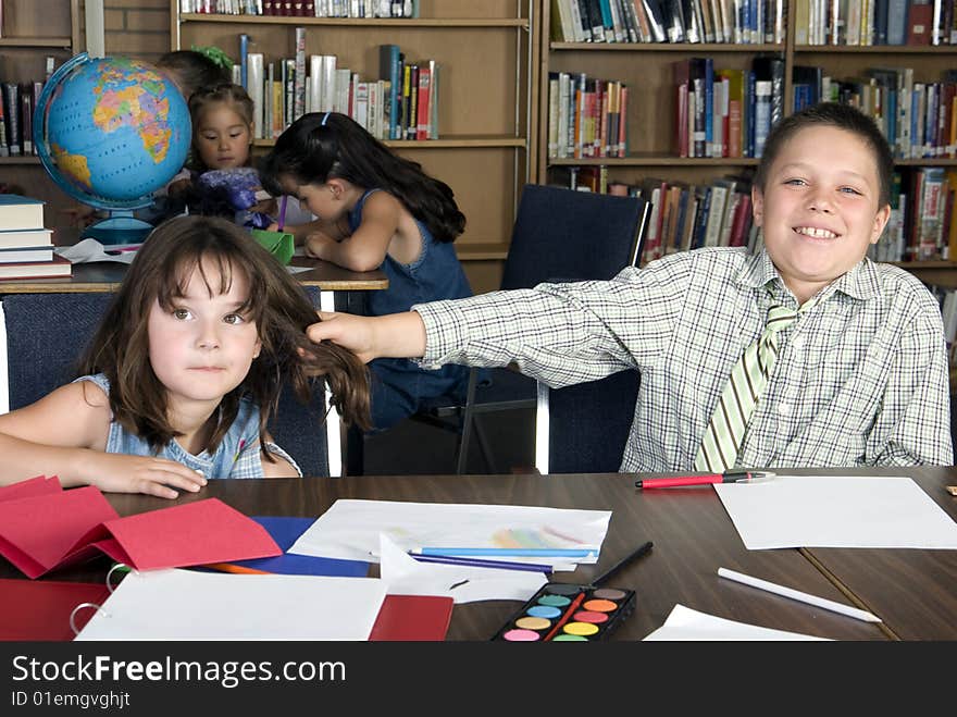 Elementary student gets her hair pulled while studying in library. Elementary student gets her hair pulled while studying in library