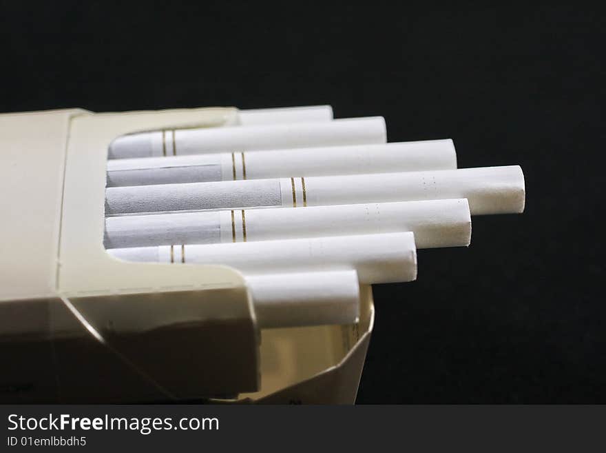 The opened pack of cigarettes on a black background