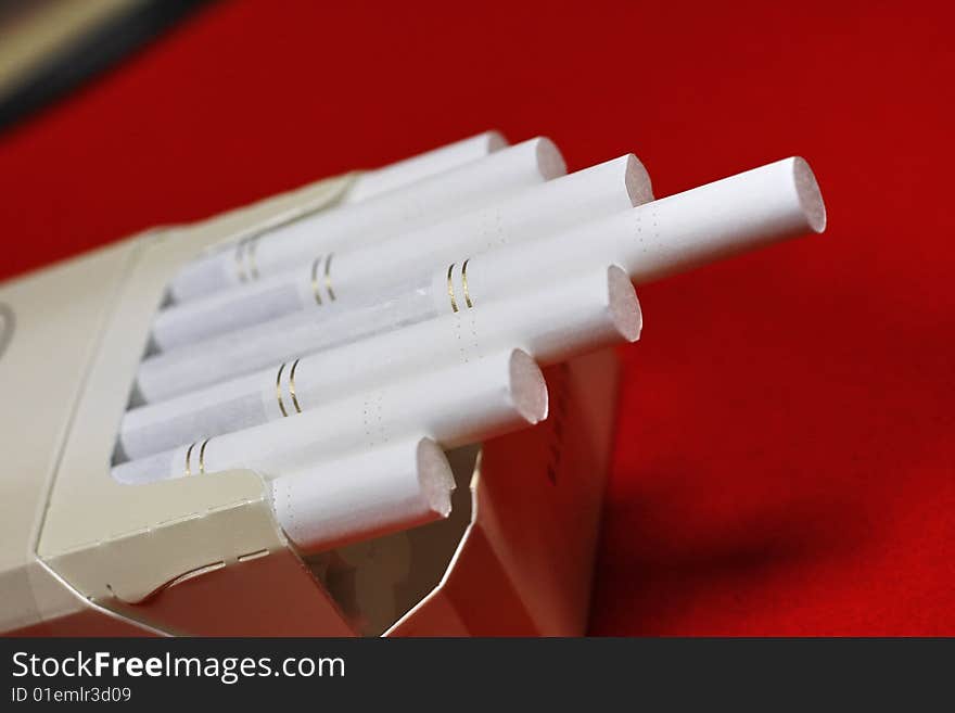 The opened pack of cigarettes on a red background