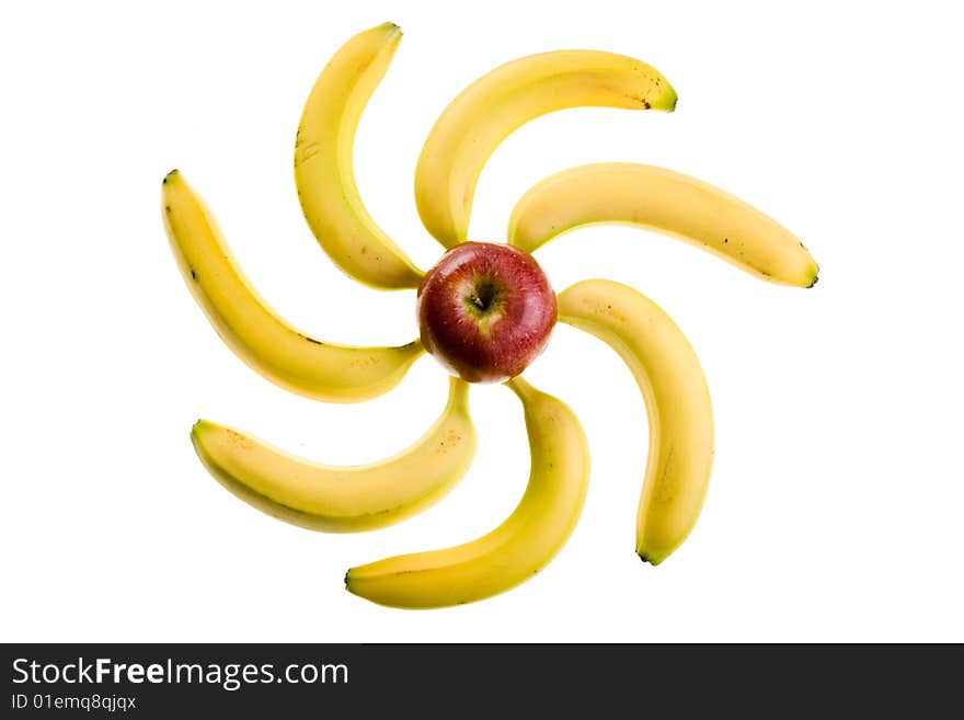 Composition from an apple and bananas in the form of the sun or flower on a white background. Composition from an apple and bananas in the form of the sun or flower on a white background