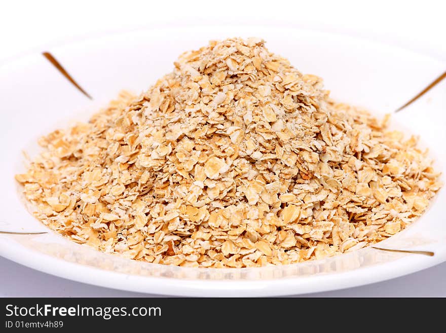 Close up of a pile of oat put on white plate. Close up of a pile of oat put on white plate