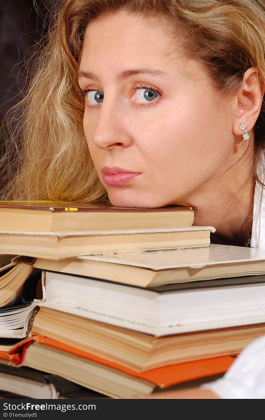 Young tired woman with a pile of books. Young tired woman with a pile of books