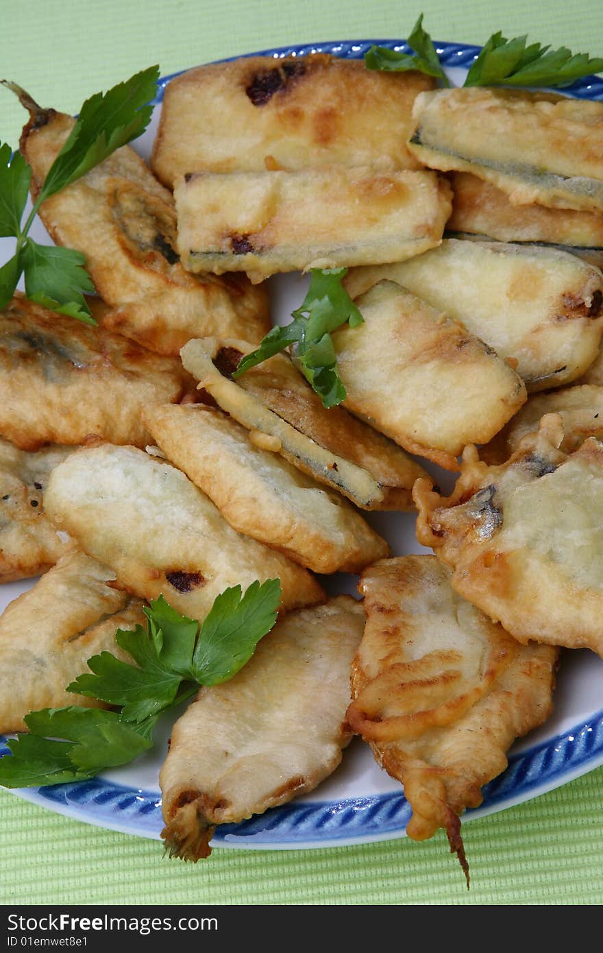 Breaded deep fried zucchini and anchovies close up