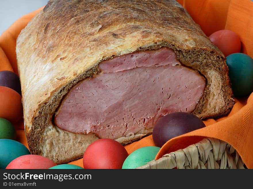 Easter ham on bread with colored eggs on plate