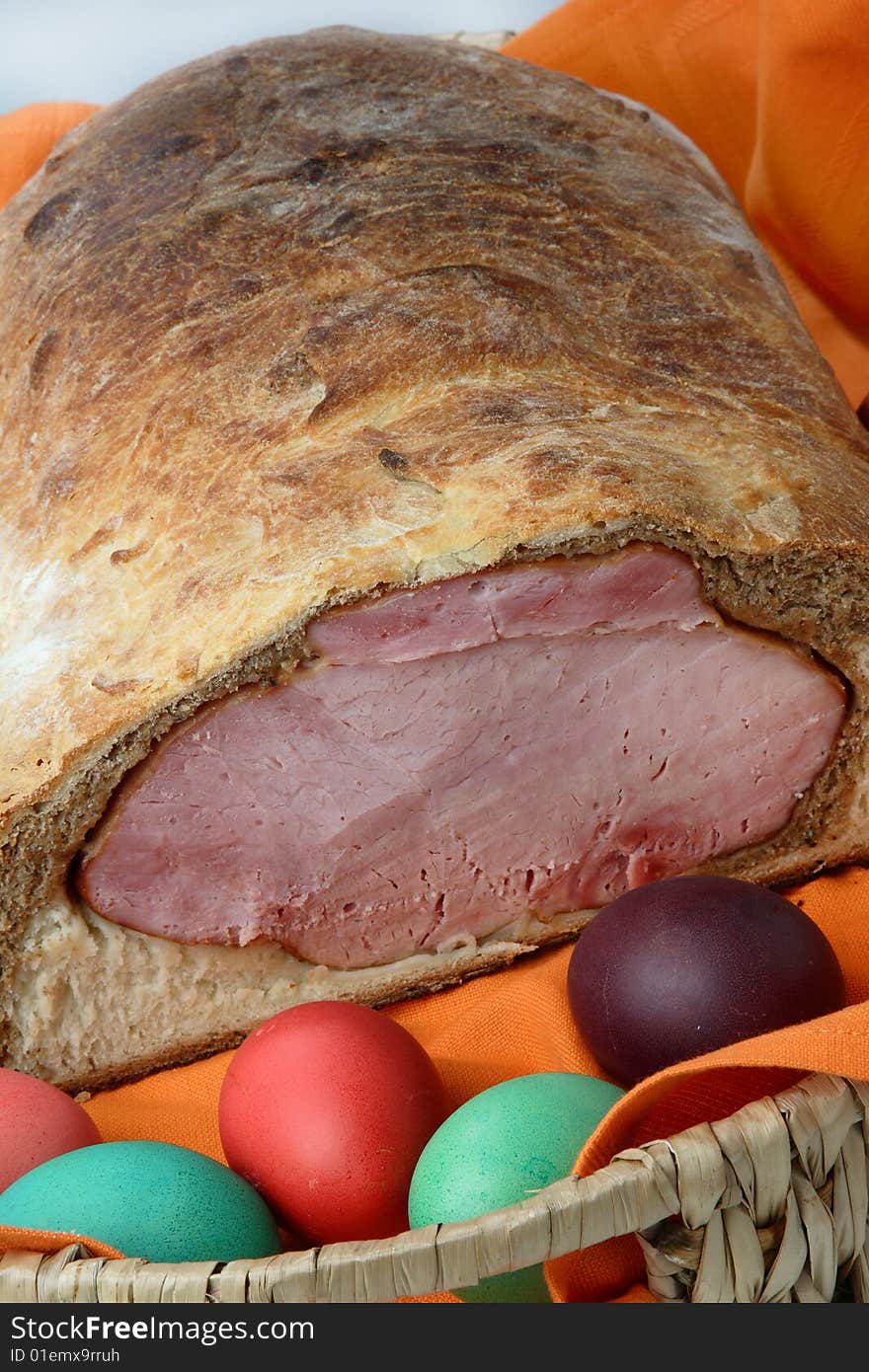 Easter ham on bread with colored eggs on plate