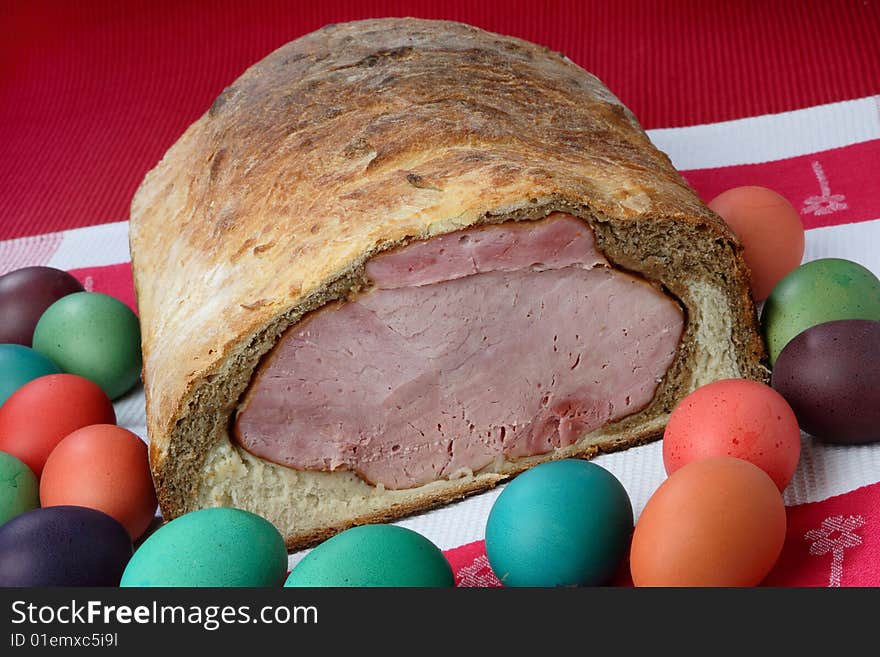 Easter ham on bread with colored eggs on plate