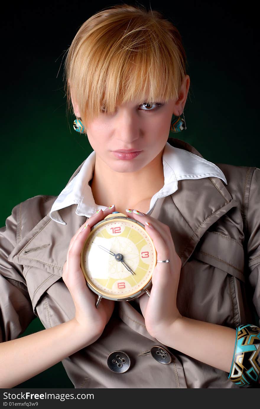 Beautiful woman with alarm clock on a black background