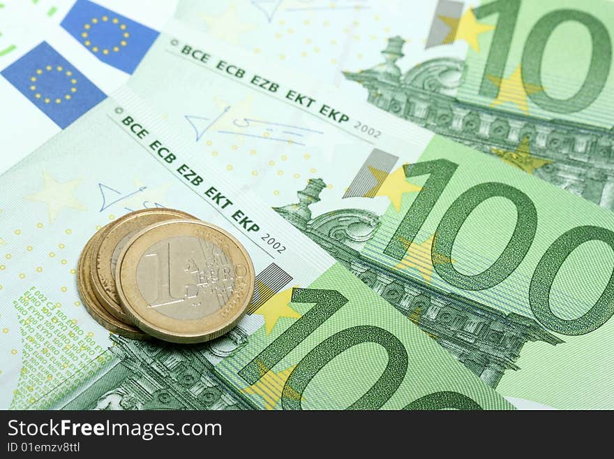 Euro banknotes with various coins