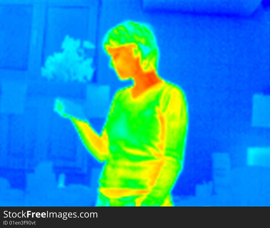 Woman reading a paper in an office. Real infrared (thermic) photo. A thermographic camera is a device that forms an image using infrared radiation and making visible the heat of the model. This image is not a digital effect. Woman reading a paper in an office. Real infrared (thermic) photo. A thermographic camera is a device that forms an image using infrared radiation and making visible the heat of the model. This image is not a digital effect.