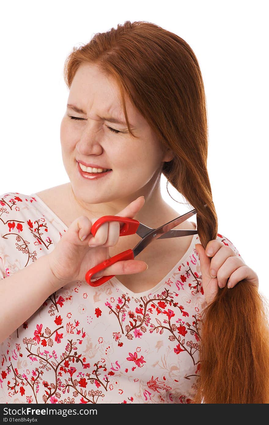 The young beautiful woman cuts red long hair