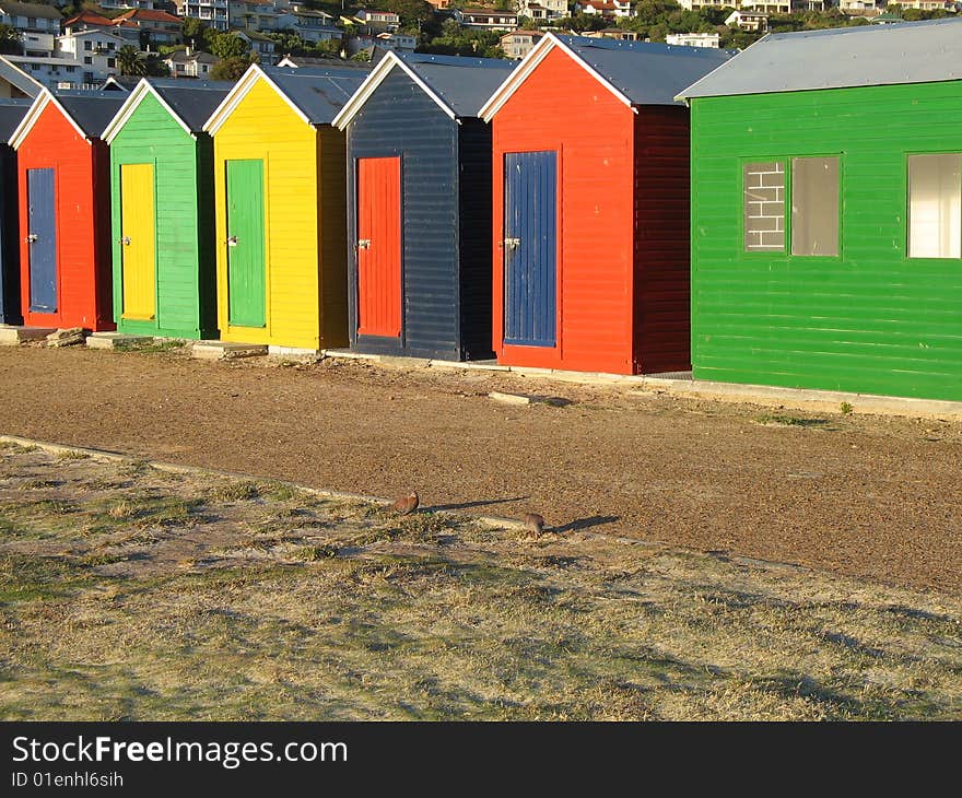 Brightly Coloured Beach huts with a mountain in the background