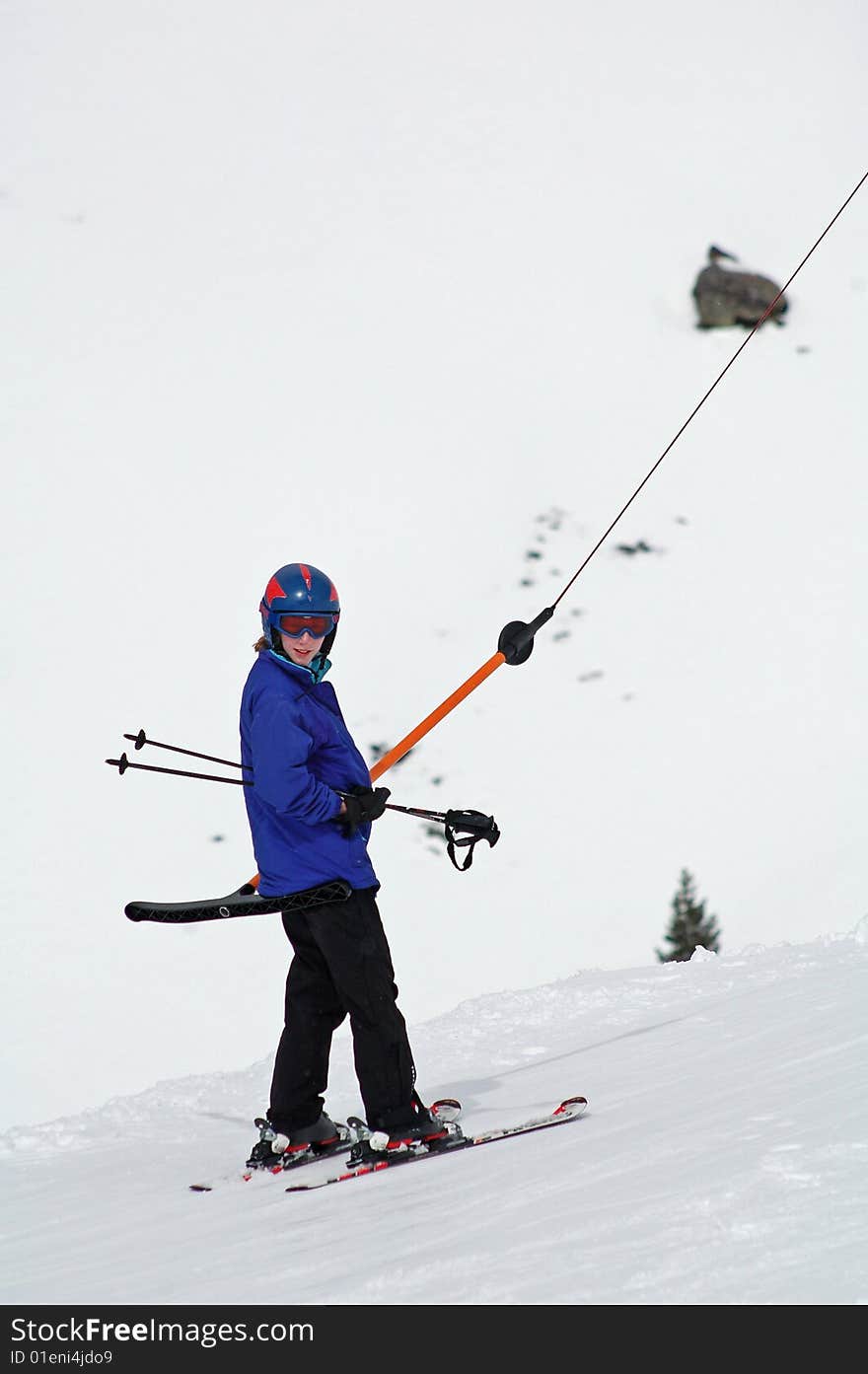 Girl going up t-bar while skiing