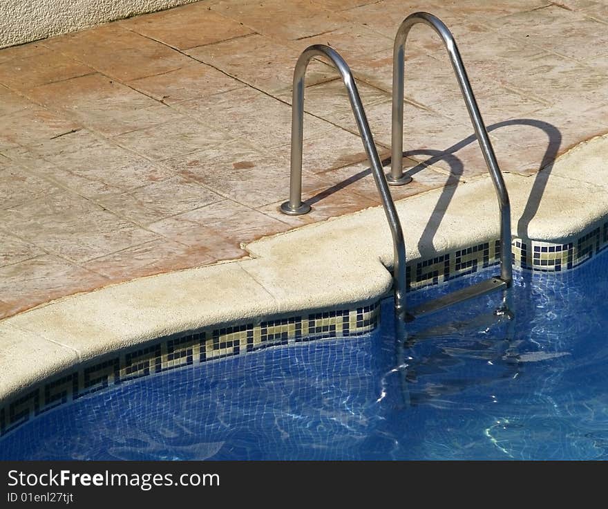 Swimming pool entrance with metal hand rail