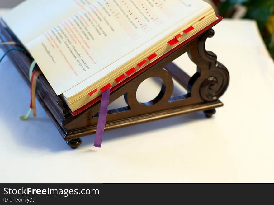 Opened bible on wooden support. Opened bible on wooden support