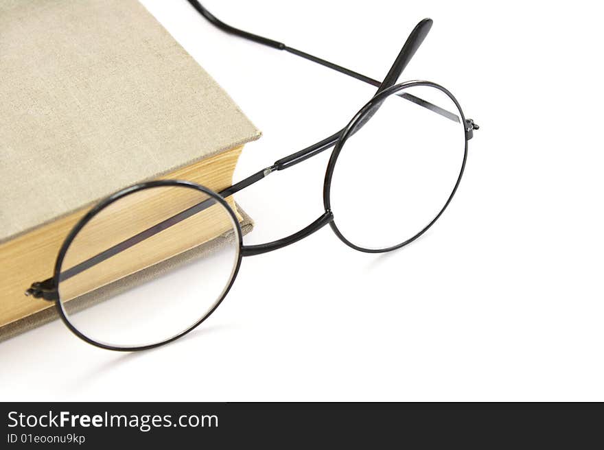 Book and glasses on a white background