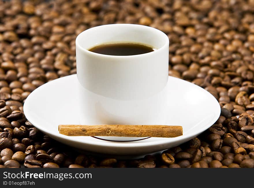 Espresso served on heart shaped cup on coffee beans