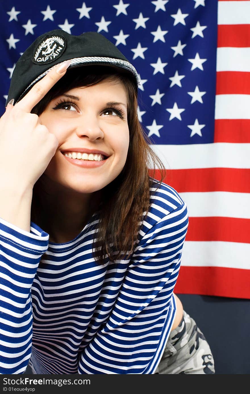 Young sailor standing opposite an American flag