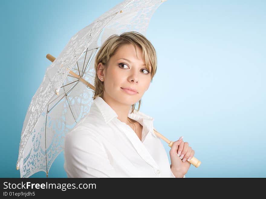 Portrait of attractive woman with lacy sunshade umbrella over blue background. Portrait of attractive woman with lacy sunshade umbrella over blue background