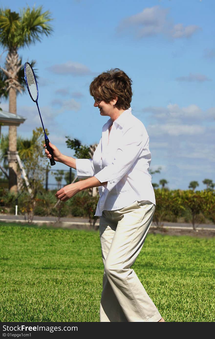 Atractive mature woman playing tennis ( badminton)