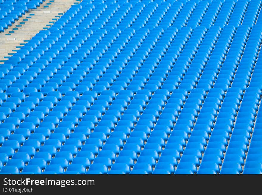 Rows and rows of blue stadium seats on an incline creating an urban abstract