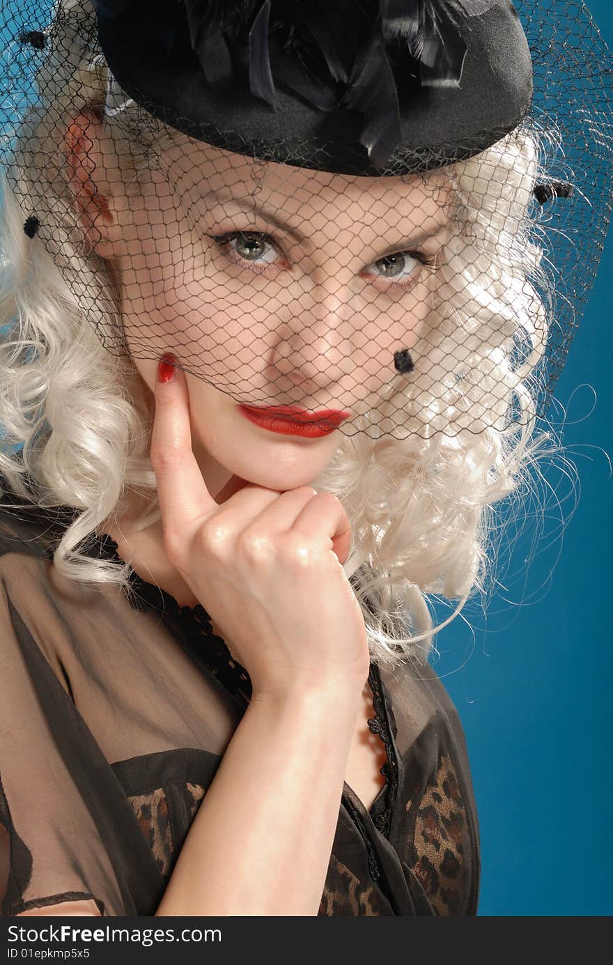 Gorgeous retro girl in forties hat with feathers