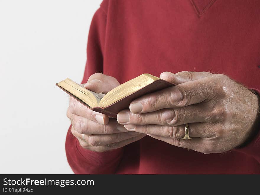 Close-up of senior male hands holding open prayerbook. Close-up of senior male hands holding open prayerbook