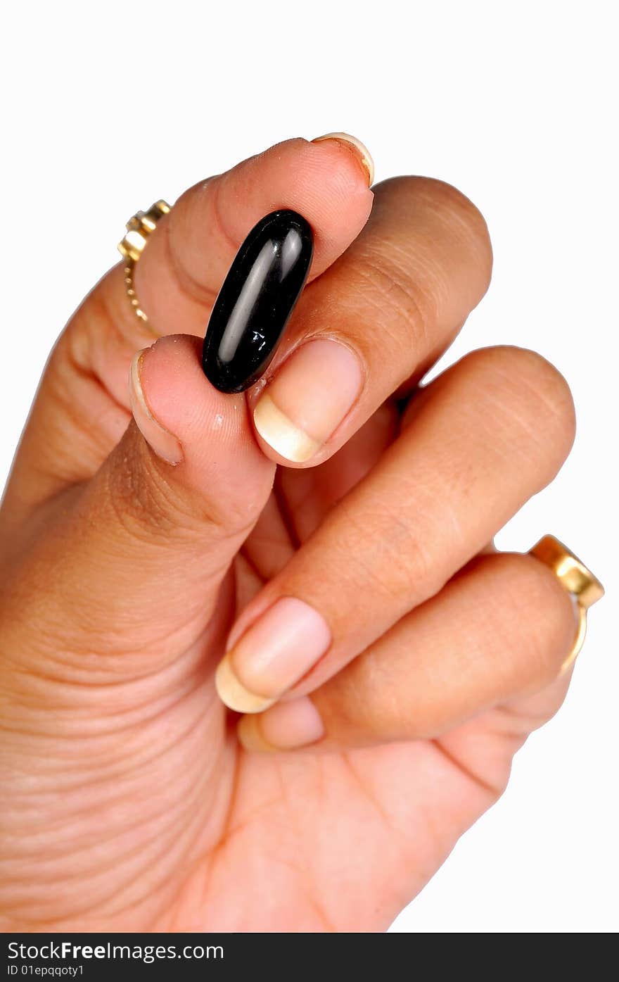 Hand holding a black capsule. Hand holding a black capsule.