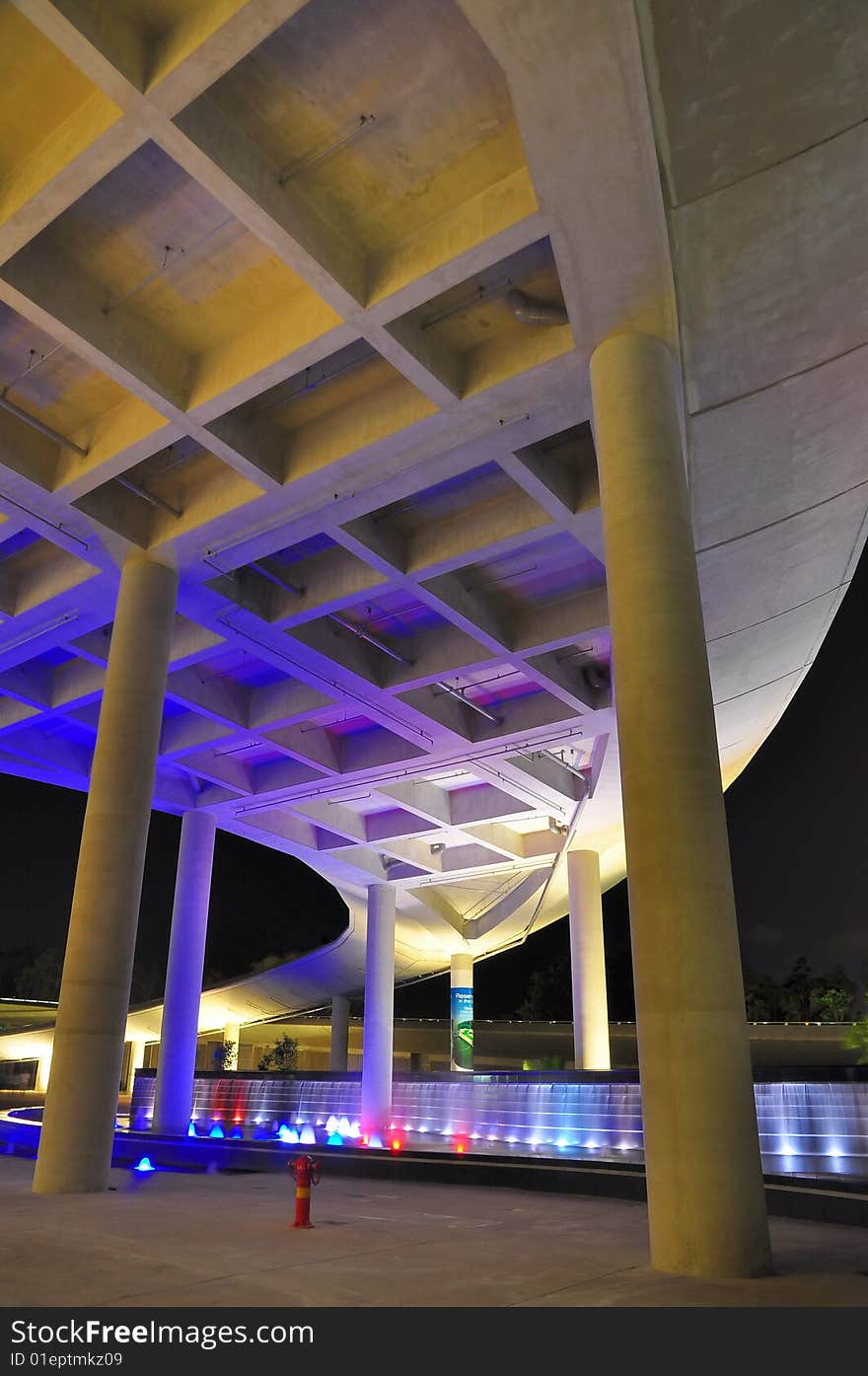 Tall bridge and fountains at night