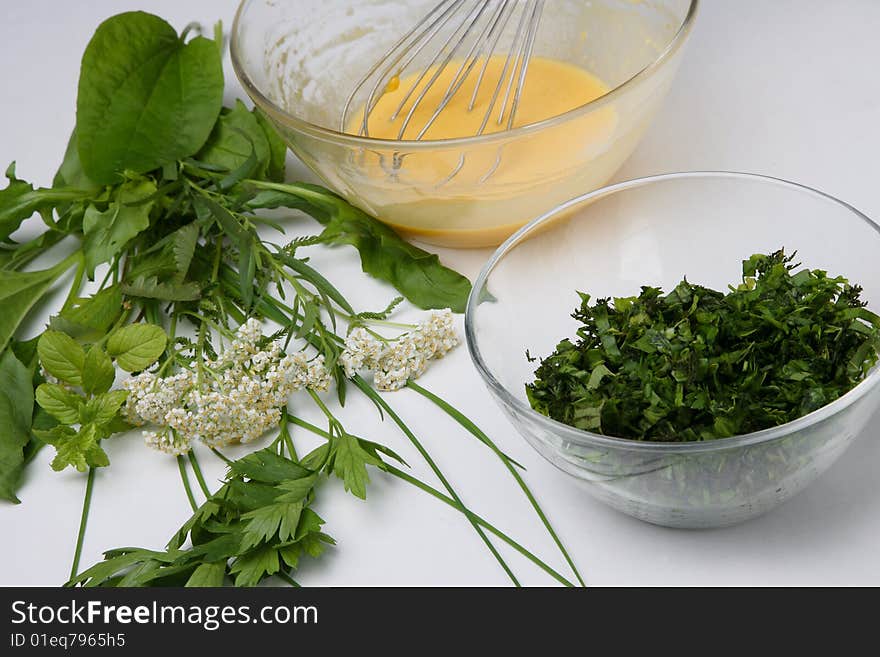 Cracked eggs and fresh herbs in bowls