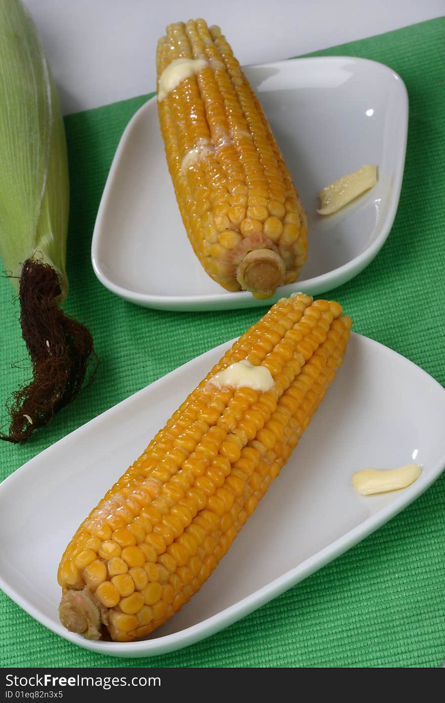 Boiled corn cob with butter on plate