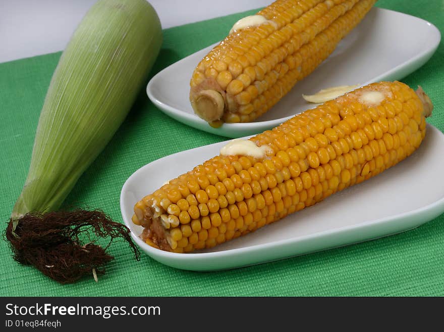 Boiled corn cob with butter on plate