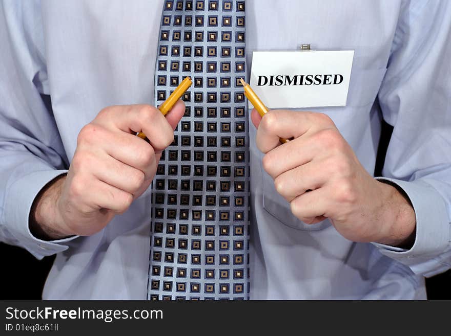 A fragment of the official styled person with badge DISMISSED and bloken pencil in hands. A fragment of the official styled person with badge DISMISSED and bloken pencil in hands.