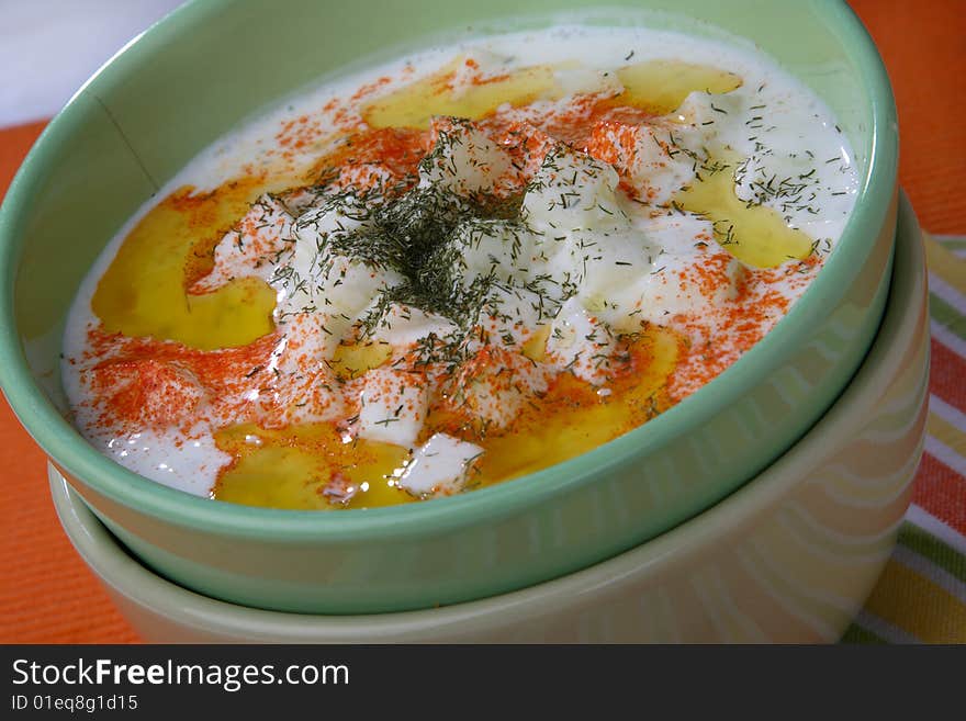 Cucumbers in cream with red pepper on plate