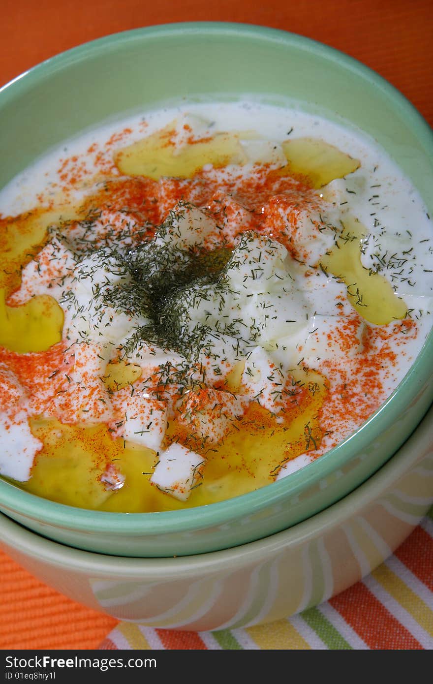 Cucumbers in cream with red pepper on plate