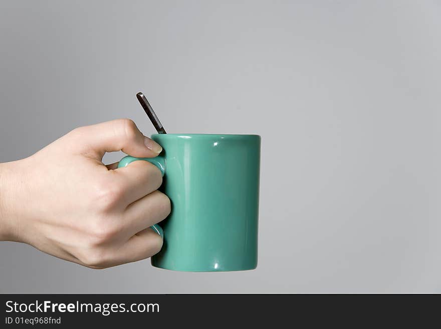 Woman Hand Holding A Tea Cup With A Spoon Close-up