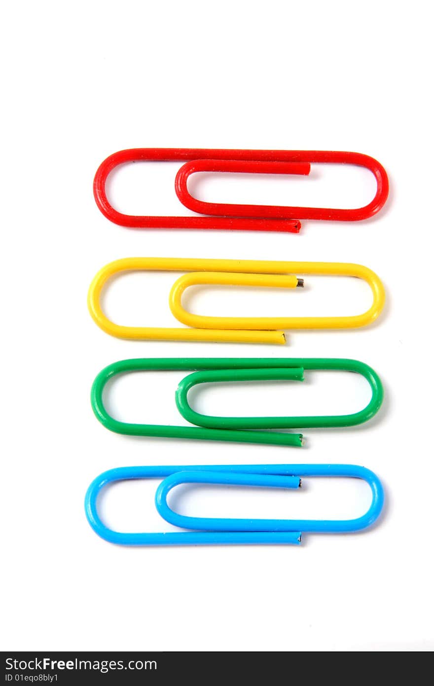 Four writing paper clips of different color on a white background.