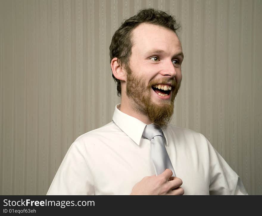 Young business man laughing while holding tie. Young business man laughing while holding tie